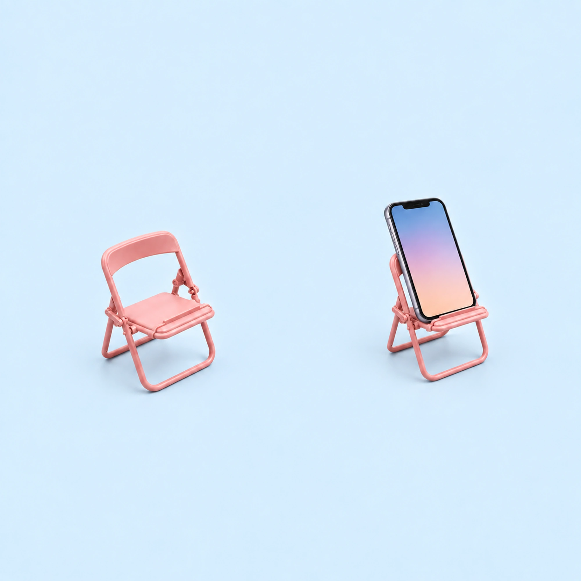Pink Mini Folding Chair Phone Stand shown in use on a light blue background; demonstration device not included